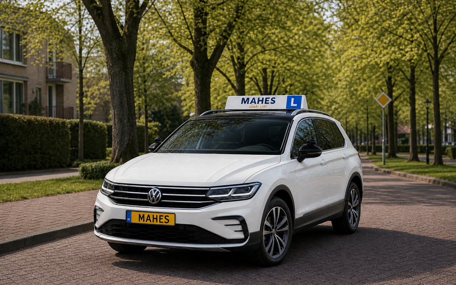 Witte lesauto van MAHES sinds 1981 met geel MAHES-kenteken voor een Engelstalige opfrisles